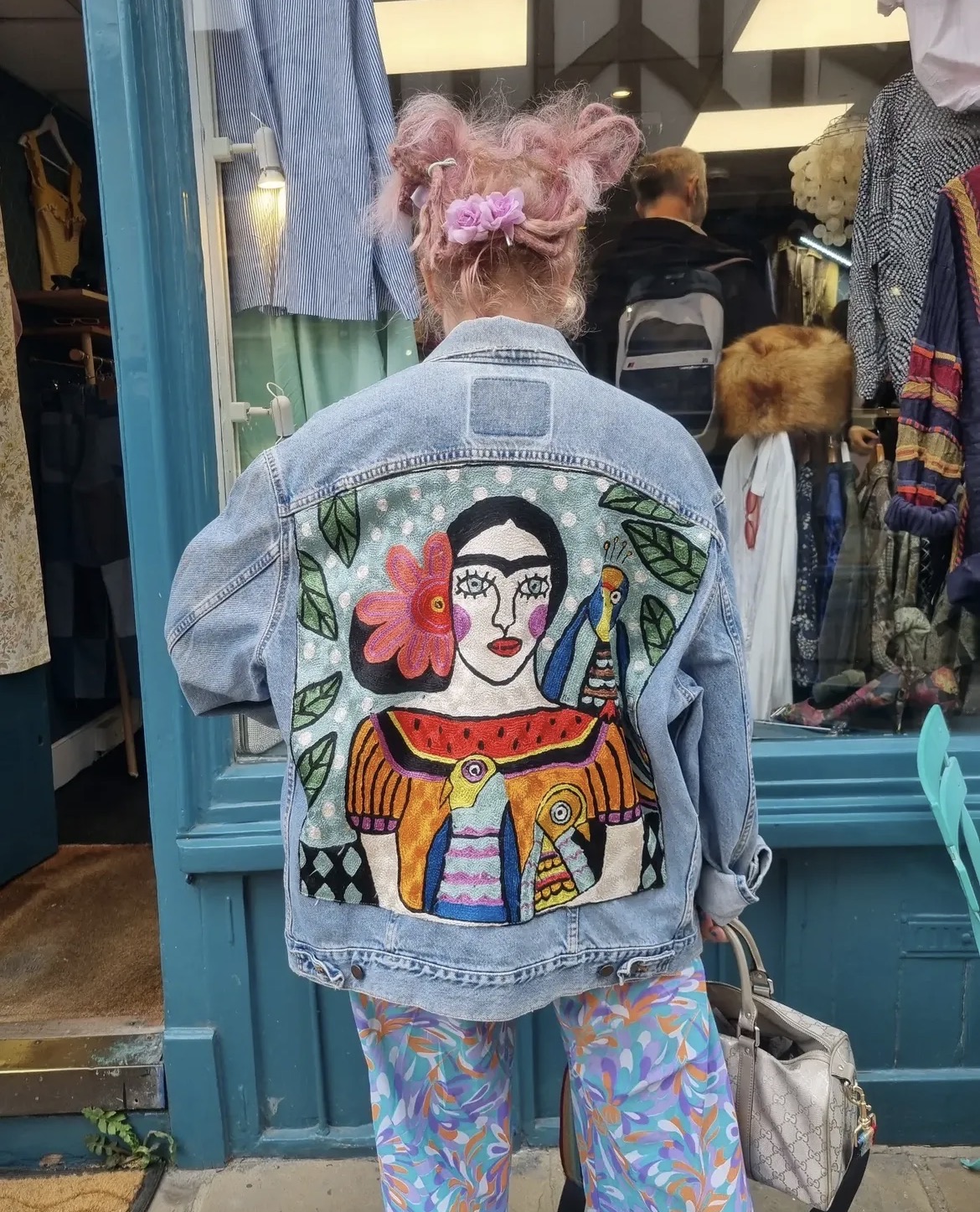 Karma Studio hand-embroidered Frida denim jacket worn outside the teal Burgate shopfront