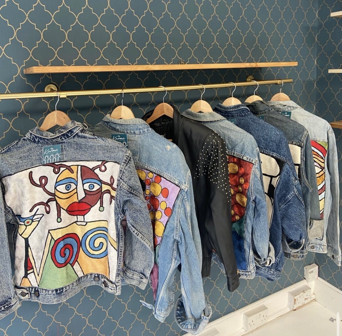 A rail of one-of-one embroidered denim jackets hanging in the Karma Studio shop