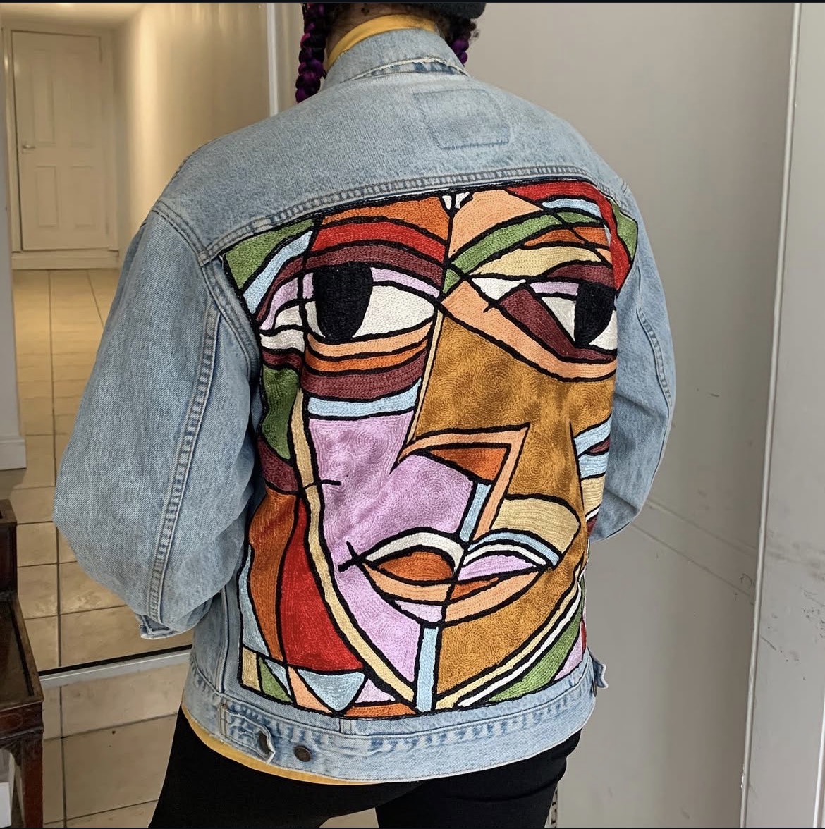 Multicolour cubist face hand-embroidered on the back of a vintage denim jacket